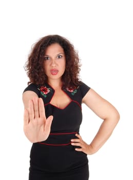 A angry young woman in a black dress holding her hand up and telling.come not close, isolated for white background..