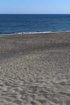 The Kamari beach with black volcanic stones at Santorini island, Greece
