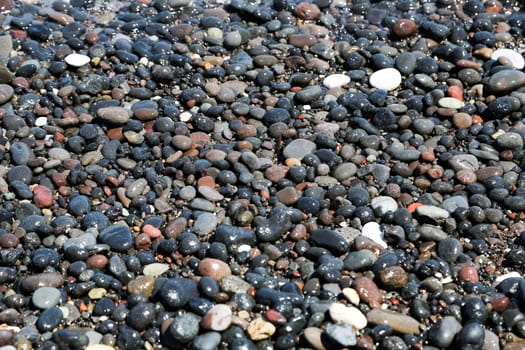 The Kamari beach with black volcanic stones at Santorini island, Greece