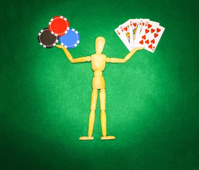 The wooden man with hands up to hold chips and cards for playing poker
