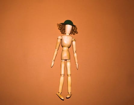 The wooden woman with hat and hair on brown background