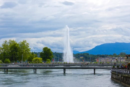 Panoramic view of historic Geneva famous Jet d'Eau fountain at harbor district with blue sky and clouds in summer, Canton of Geneva, Switzerland