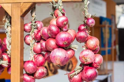 Red onion braids sold in Italy in the Farmer's Market.