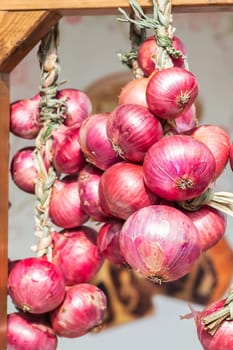 Red onion braids sold in Italy in the Farmer's Market.