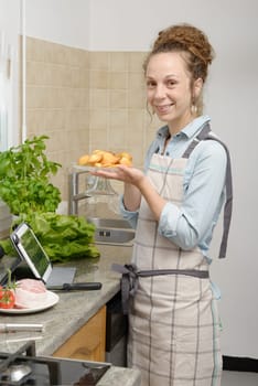 a young woman with madeleine cookies in the kitchen