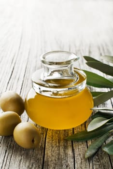 Olive oil in a bottle on a wooden table