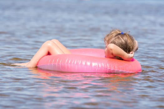 Five-year girl swims in the river sat on the swimming circle