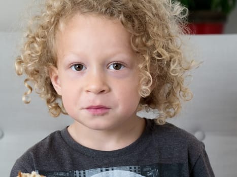 a portrait of a little boy with blond curly hair