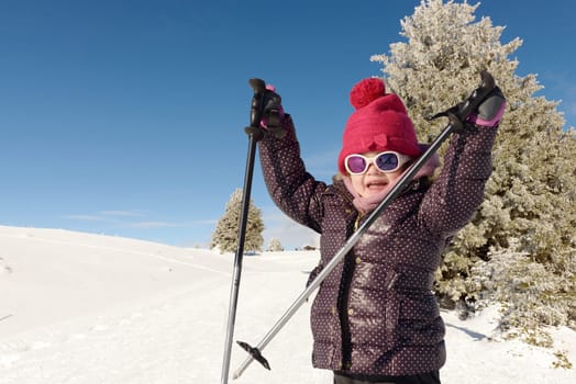 a happy little girl skiing downhill