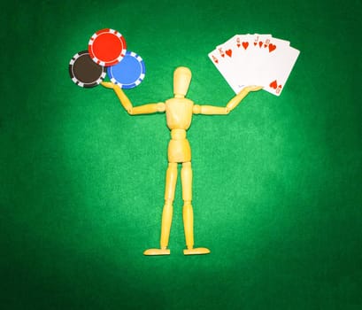 The wooden man with hands up to hold chips and cards for playing poker