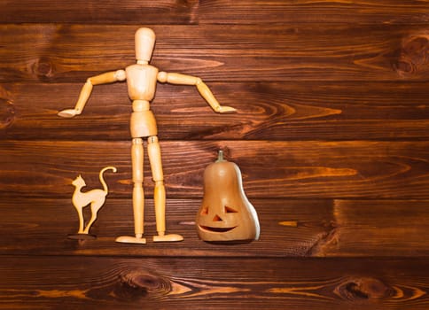 The Halloween concept - wooden man with pumpkin and cat on wooden background