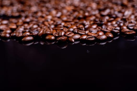 a lot of brown roasted coffee beans on black ground