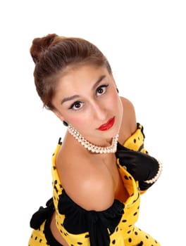 A beautiful young woman in a yellow dress and black cloves looking up.into the camera, isolated for white background..
