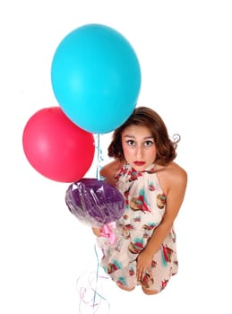 A beautiful woman kneeling on floor and looking up with a lollypop and.two balloons, isolated for white background..