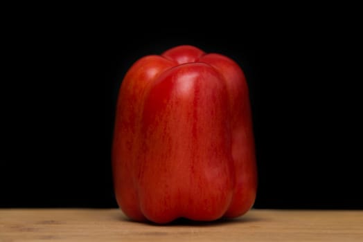 close up on red paprika on wood,black background