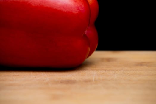 close up on red paprika on wood,black background