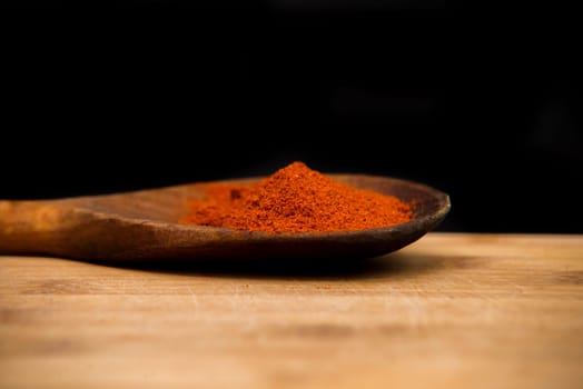 close up on paprika powder in wood bowl