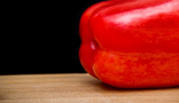 close up on red paprika on wood,black background
