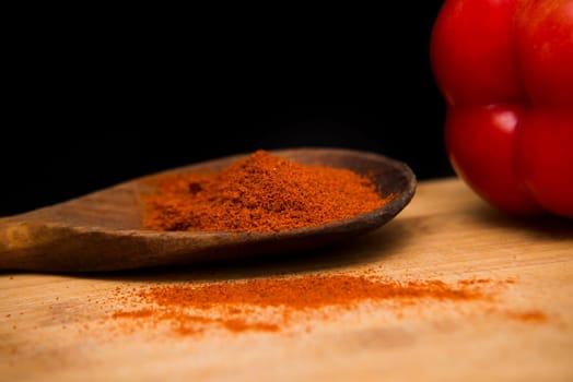 close up on paprika powder in wood bowl