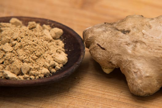 close up on fresh ginger and powder on wood