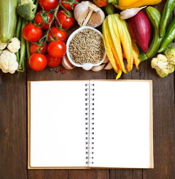 Raw Rye Grain in a bowl and vegetables on wood