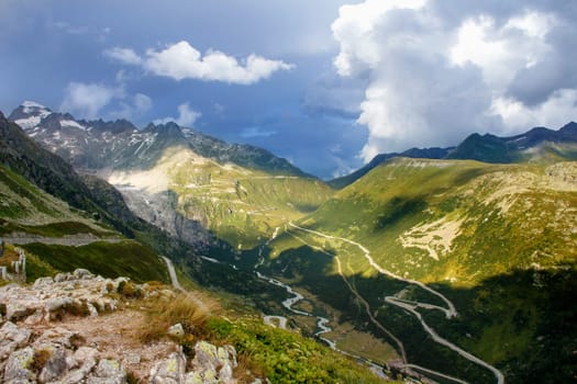 View on Alpine landscape with curved road near Grimselpass