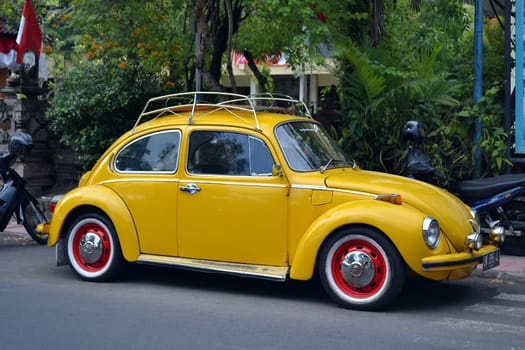 Ubud, Bali - August 28, 2016: Vintage Yellow Volkswagen Beetle Parked on a Street in Ubud, Bali