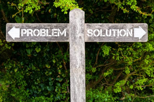 Wooden signpost with two opposite arrows over green leaves background. Problem versus Solution directional signs, Choice concept image