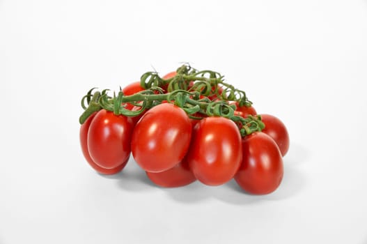 Red ripe tomatoes on the green line close up on white