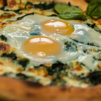 Margarita pizza with arugula and egg for breakfast, selective focus