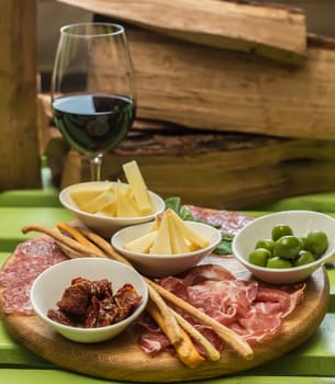 different italian antipasti and red wine. selective focus
