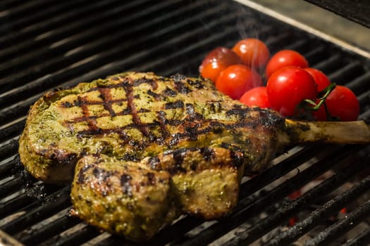 steak flame broiled on a barbecue with vegetables. shallow depth of field.