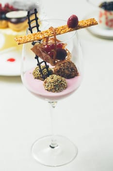 Close up of chocolate truffles with raspberry yogurt in elegant glasses. Warm colors. Shallow dof.