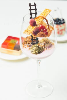 Close up of chocolate truffles with raspberry yogurt in elegant glasses. Warm colors. Shallow dof.
