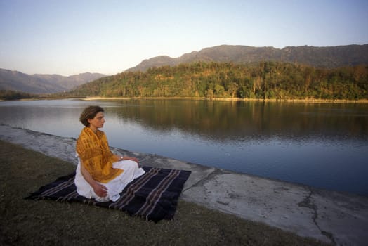 a woman on the Ganges River in the town of Rishikesh in the Province of Uttar Pradesh in India.