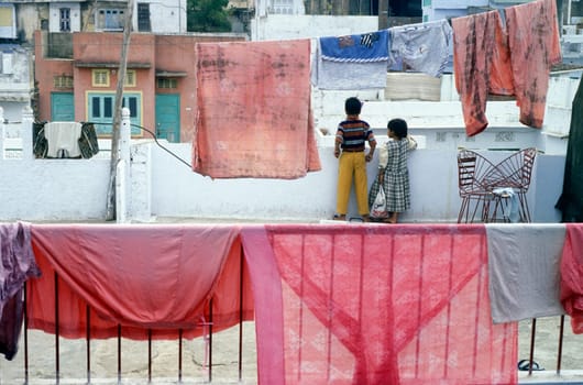 Childern on the roof top on a House in the city of Udaipur in the province of Rajasthan in India.
