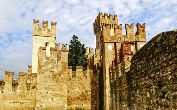 Sirmione, Italy - September 20, 2014: Scaliger Castle. The famous castle of Sirmione and its small port are an uncommon example of a fortress used as a port. The building of this complex started in 1277 by Mastino della Scala.