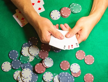 The male hands with cards in casino and chips