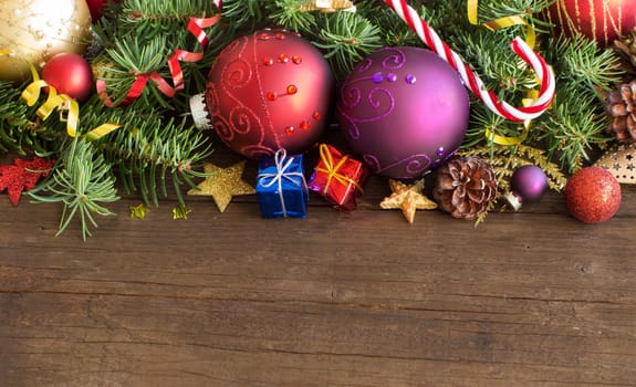 Colorful Christmas decorations - baubles, stars and pine cones on wood