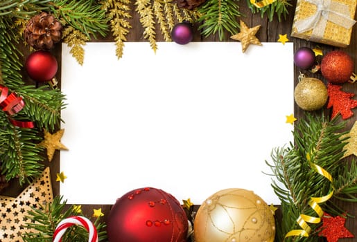 Christmas composition with decorations and paper on wood