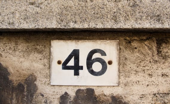 Number forty six on the grey stone wall close up