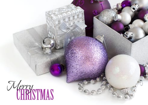 Silver and purple Christmas ornaments border on white background