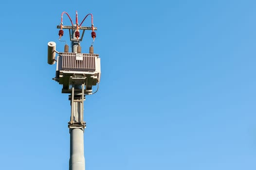 Electrical transformer to electrical pylon against the blue sky