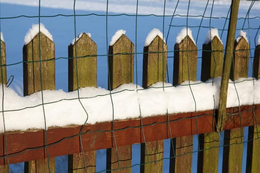 A wooden fence covered with white snow