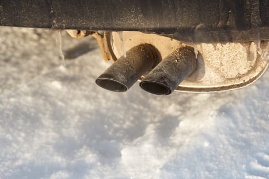 Car exhaust pipes with ice covering them