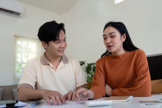A couple reviews their expenses and calculates bills together, fostering teamwork and communication in financial matters.
