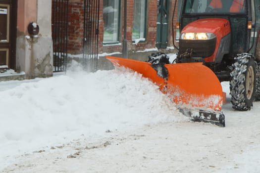 A tractor cleaning snow from the street