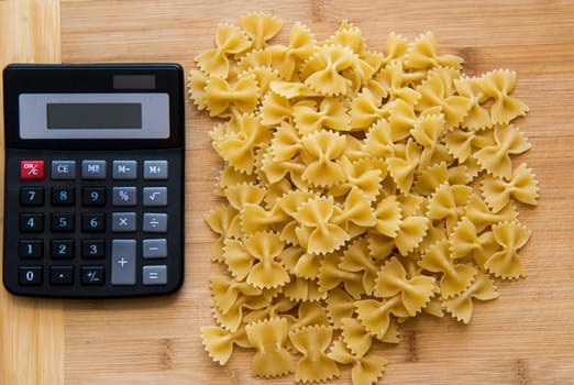 calulator with pasta on wooden background,calories