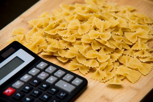 calulator with pasta on wooden background,calories
