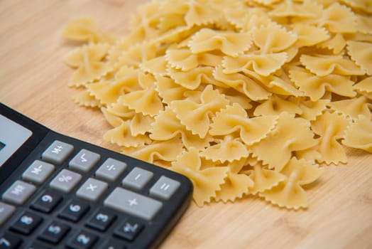 calulator with pasta on wooden background,calories
